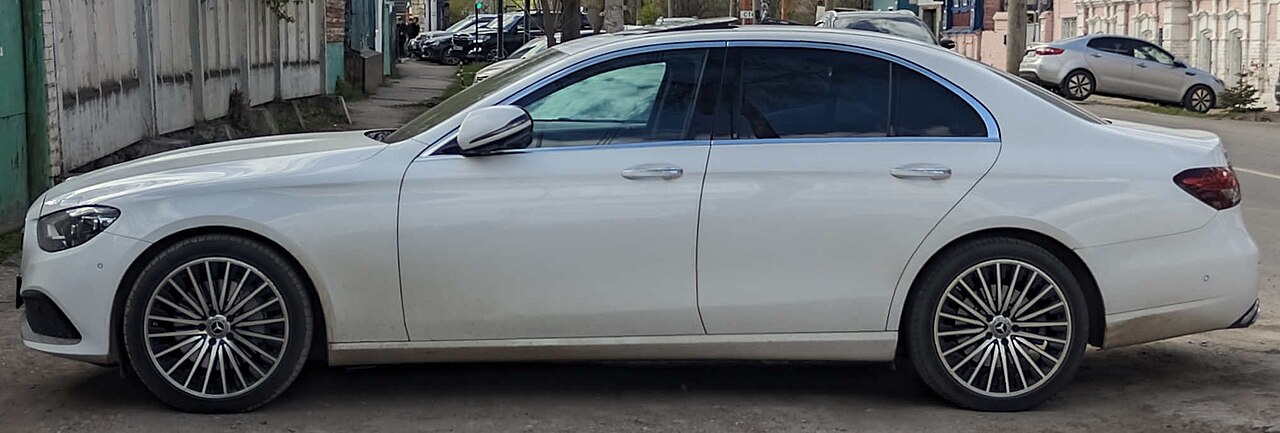 White Mercedes-Benz E-Class in side profile, with no visible licence plate